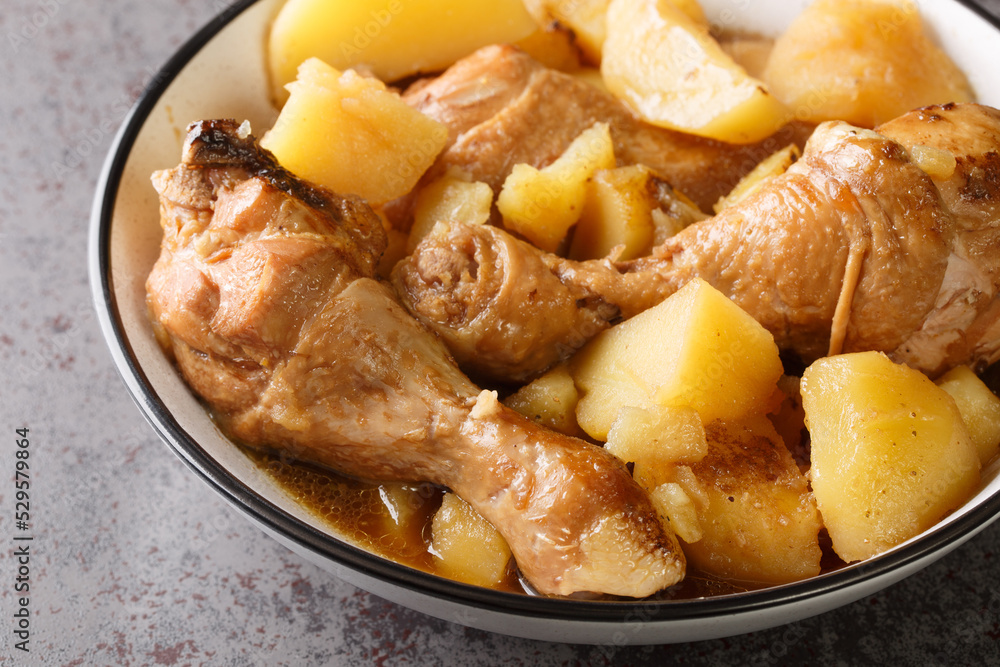 Semur Ayam Chicken Stew in Sweet Soy Sauce with potatoes served on a white plate closeup on the table. Horizontal