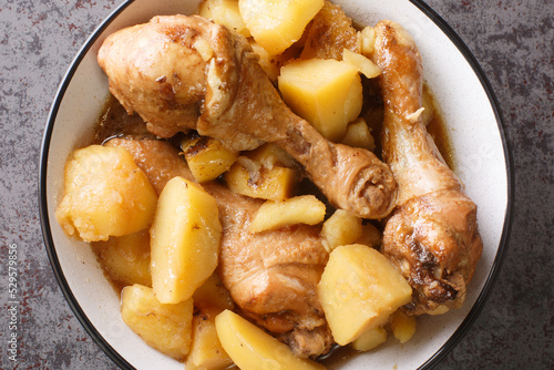 Semur Ayam Chicken Stew in Sweet Soy Sauce with potatoes served on a white plate closeup on the table. Horizontal top view from above photo