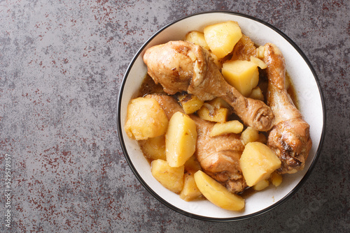 Indonesian cuisine chicken drumsticks stewed with potatoes in spicy sweet soy sauce close-up on the table. horizontal top view from above photo