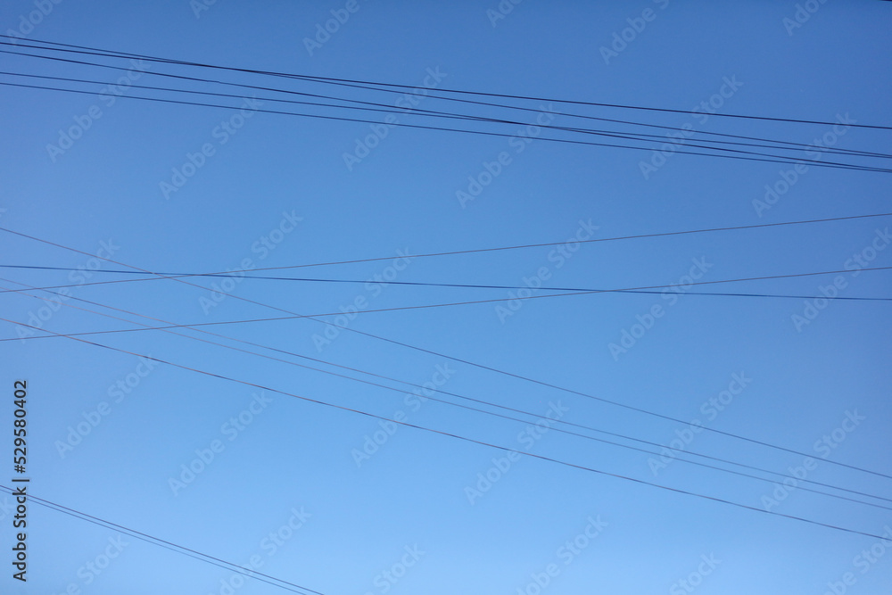 Electric wires against the blue sky. Background Electric wires against the blue sky. Background