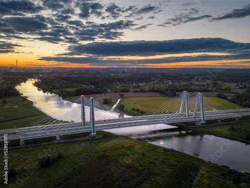 Oświetlony most nad rzeką w czasie zachodu słońca