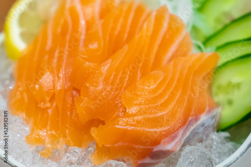 Salmon Sashimi, Japanese food, served with sliced cucumber and lemon over ice.