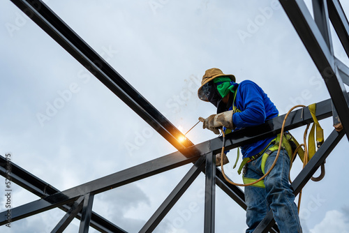 Asian construction worker believes steel structure in industrial building construction site photo