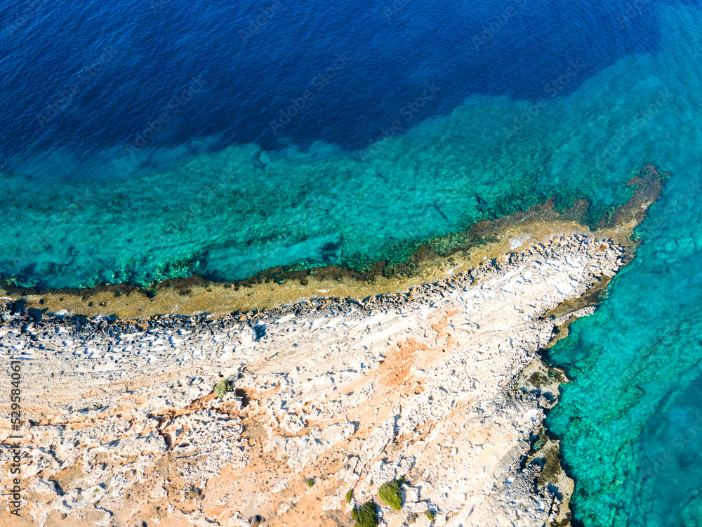Marine background of the Mediterranean sea surface. Top view from a drone. Stone cape of the island. Exotic water landscape. Natural tropical paradise. Camping in Cyprus.