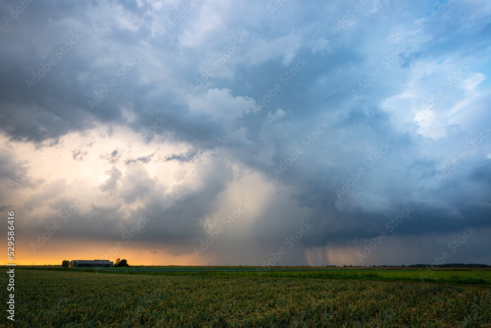 Naklejka premium Ominous spectacle as threatening clouds of a thunderstorm pass in the evening light