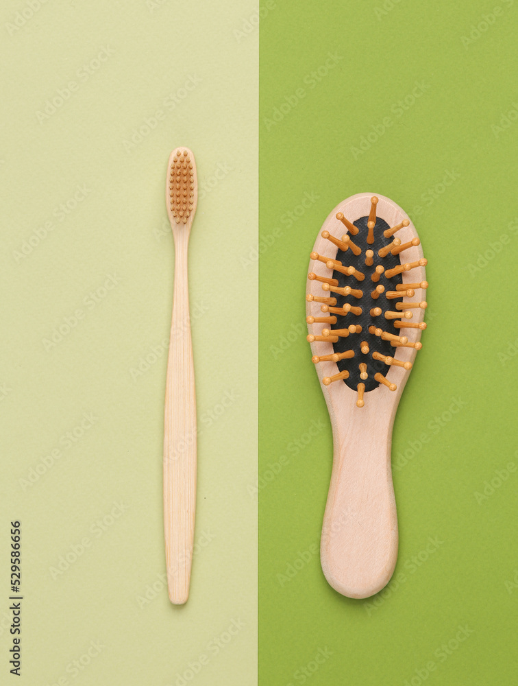 Wooden hair brush and toothbrush on green background. Eco Products, environmentally friendly Wooden hair brush and toothbrush on green background. Eco Products, environmentally friendly