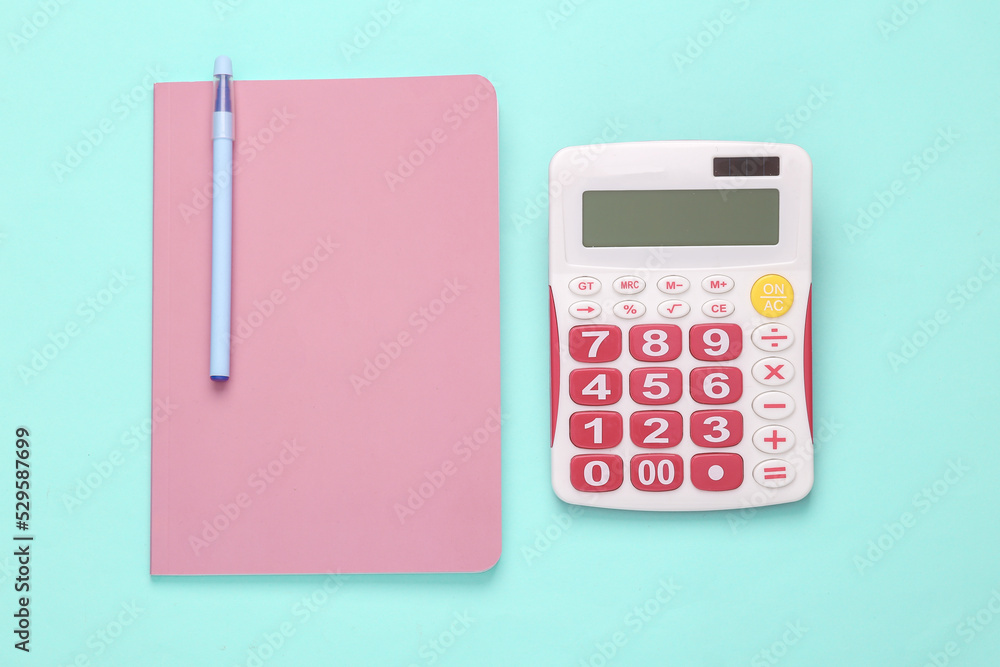 Calculator with notebook on a blue-pink pastel background. Business concept. Top view Calculator with notebook on a blue-pink pastel background. Business concept. Top view
