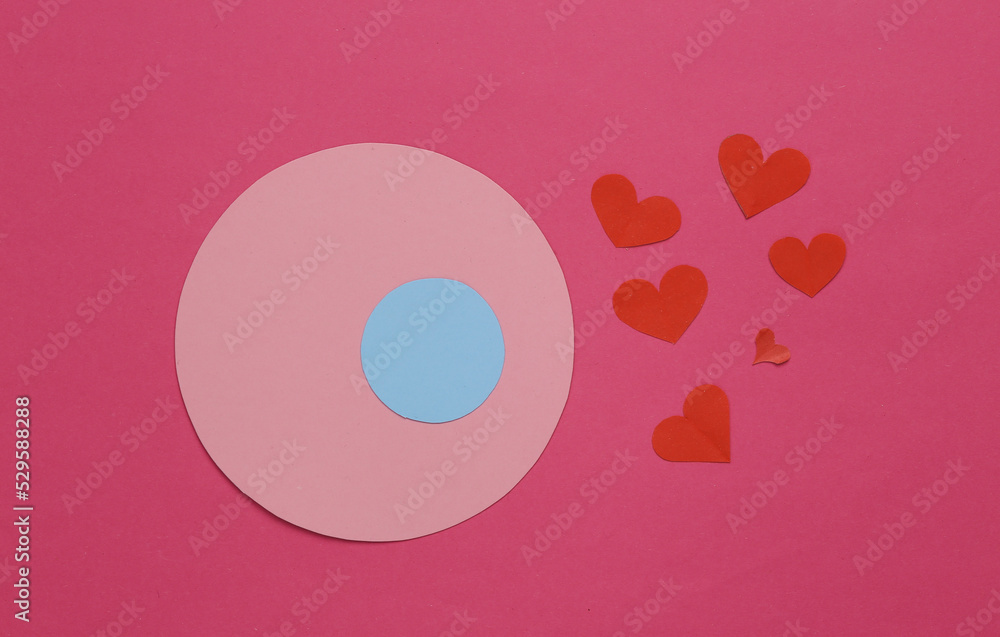 Love, ovulation, conception concept. Egg and paper cut hearts on a pink background Love, ovulation, conception concept. Egg and paper cut hearts on a pink background