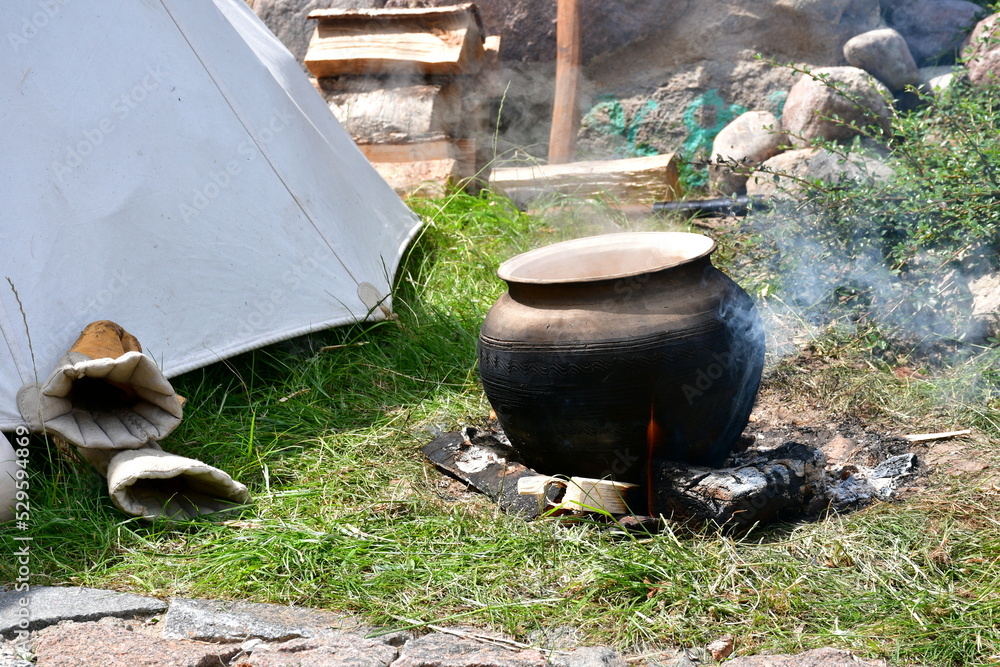 A close up on a clay pot used for cooking meals in a hurry standing on