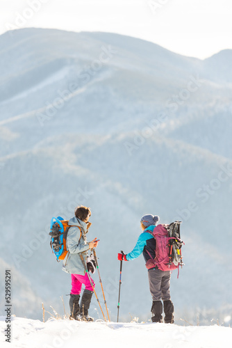 two girls travel in the mountains of winter.