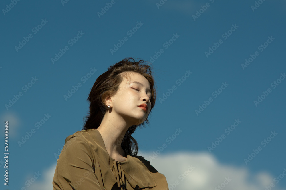 closeup portrait of a beautiful young lady against the blue sky closeup portrait of a beautiful young lady against the blue sky
