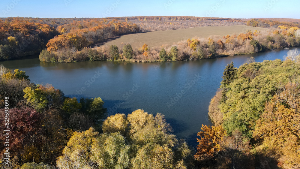 Fototapeta premium View from a height of the autumn forest on the banks of the river 