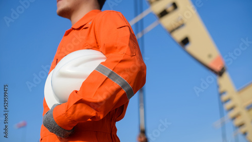 man working in Oil field site, climb oil tank for working