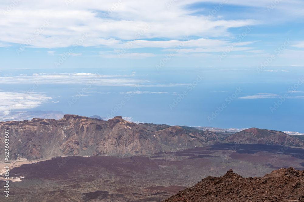 Panoramic view from the summit of volcano Pico del Teide over the island of Tenerife, Canary Islands, Spain, Europe. Vista on barren landscape, Solidified lava, ash, pumice. Atlantic Ocean sea vista