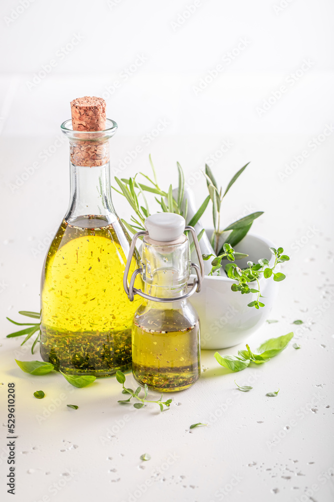 Delicious and healthy oil in bottle with herbs.