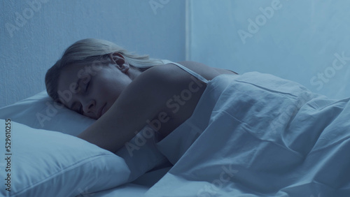 Fotografie Young woman lying in the bed at night