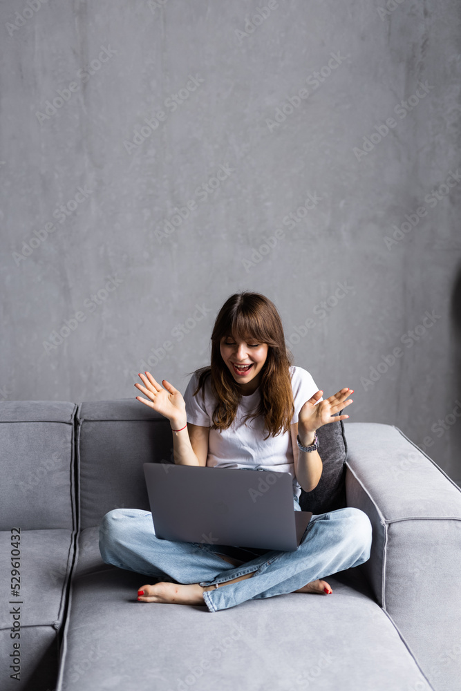 Excited woman looking at laptop screen, screaming with joy, surprised by message with good news, overjoyed young female sitting on couch at home, using computer, celebrating online win or success Excited woman looking at laptop screen, screaming with joy, surprised by message with good news, overjoyed young female sitting on couch at home, using computer, celebrating online win or success