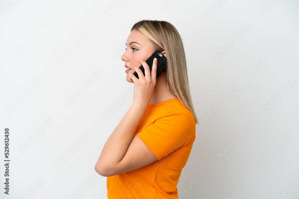 Young caucasian woman isolated on white background keeping a conversation with the mobile phone with someone Young caucasian woman isolated on white background keeping a conversation with the mobile phone with someone