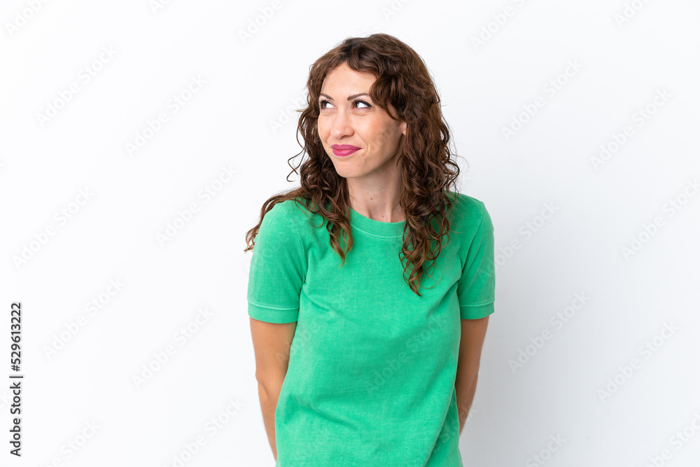 Young woman with curly hair isolated on white background having doubts while looking up Young woman with curly hair isolated on white background having doubts while looking up