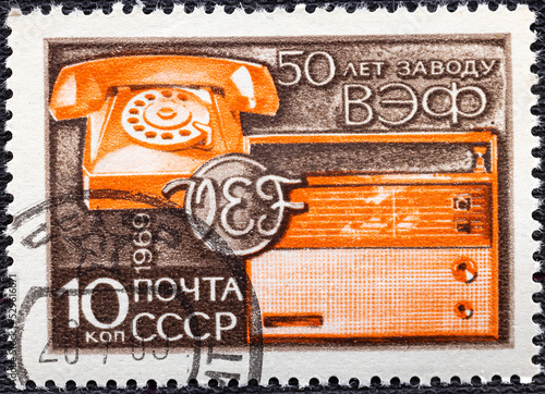 USSR - CIRCA 1969: A stamp printed in USSR shows Telephone, Transistor Radio, 50th anniversary of VEF Electrical. photo