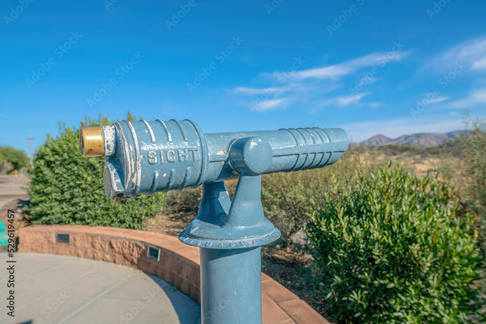 Public telescope for tourists to view distant mountains and nature landscape