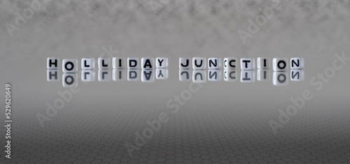 holliday junction word or concept represented by black and white letter cubes on a grey horizon background stretching to infinity