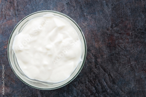 Yogurt in a bowl. Greek yogurt on a dark background. Dairy product for a healthy breakfast. Top view. Copy space