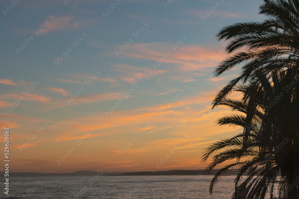 Sunset on the beach with a cloudy, blue, pink and orange sky