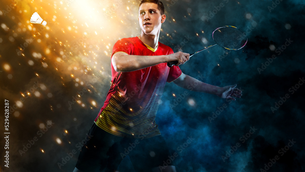Badminton player. Man with racket and shuttlecock on golden background. Individual sports. Sports recreation. Badminton player. Man with racket and shuttlecock on golden background. Individual sports. Sports recreation.