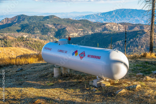 Propane flammable gas tank with mountains background on a sunny day