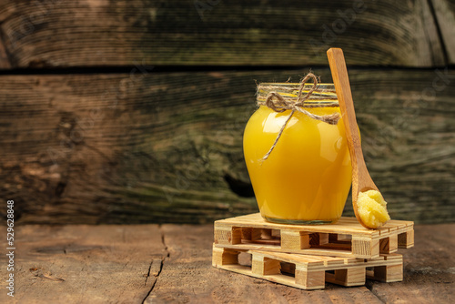 ghee oil. Ghee or clarified butter in jar on a wooden background. banner, menu, recipe place for text photo