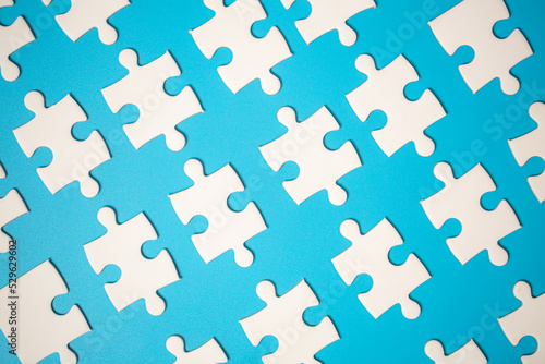 White part of jigsaw puzzle pieces on blue background. concepts of problem solving  business success  teamwork  Team playing jigsaw game incomplete  Texture photo with copy space for text