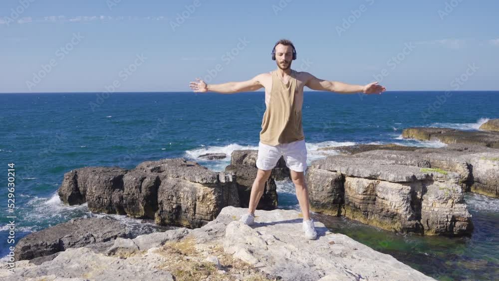 Young man doing sports against the sea.
Young man doing warm-up exercises on rocks high above sea.
Young man doing sports against the sea.
Young man doing warm-up exercises on rocks high above sea.