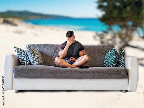 Ragazzo che sogna sul divano di casa di essere in vacanza al mare photo