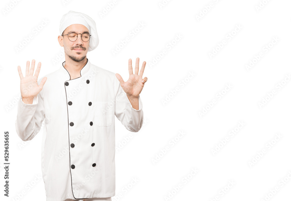 Happy young chef doing a number nine gesture with his hands Happy young chef doing a number nine gesture with his hands