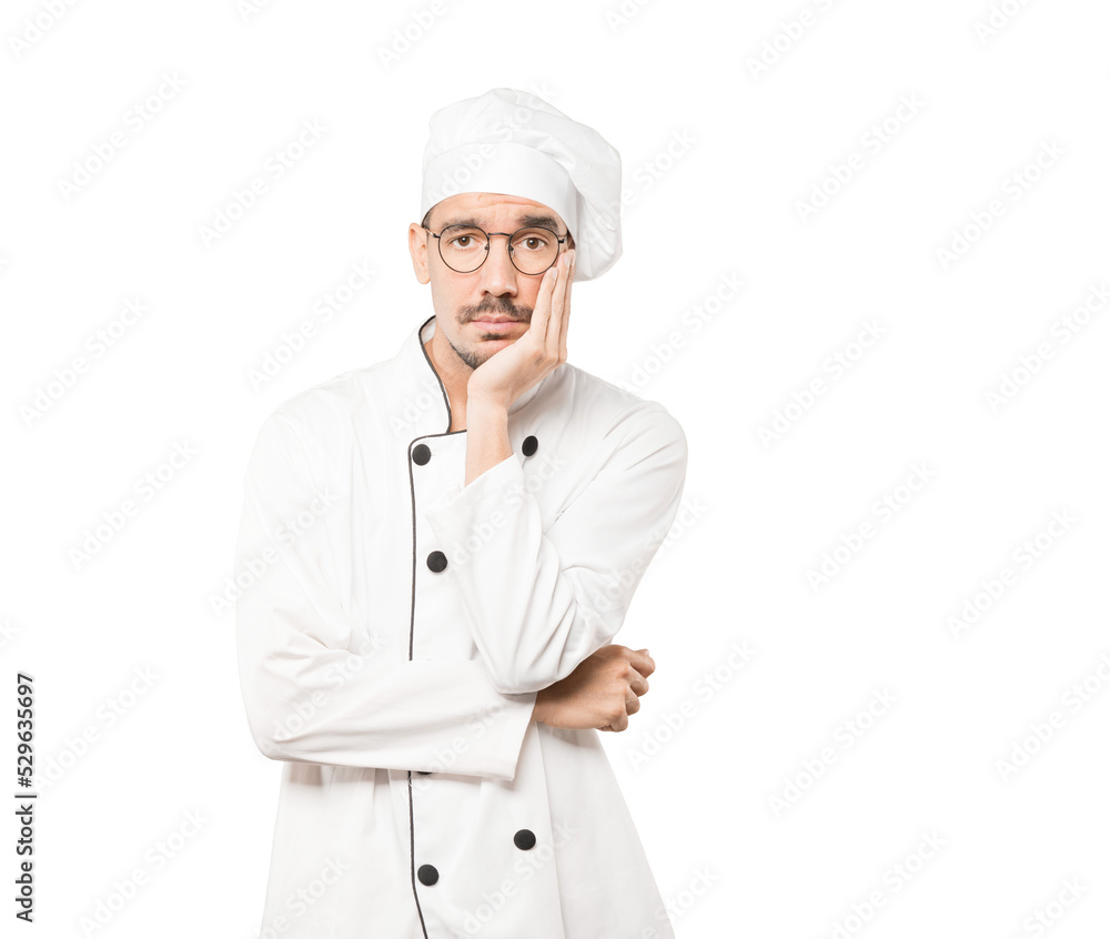 Tired young chef doing a gesture of boredom Tired young chef doing a gesture of boredom