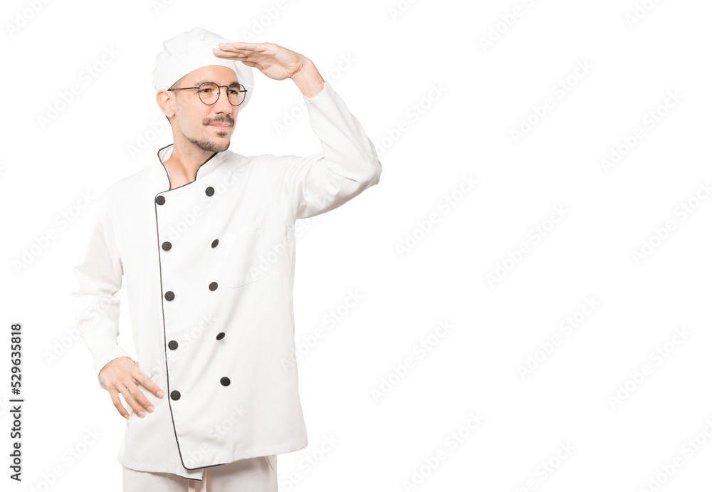 Concentrated young chef with a gesture of looking away Concentrated young chef with a gesture of looking away
