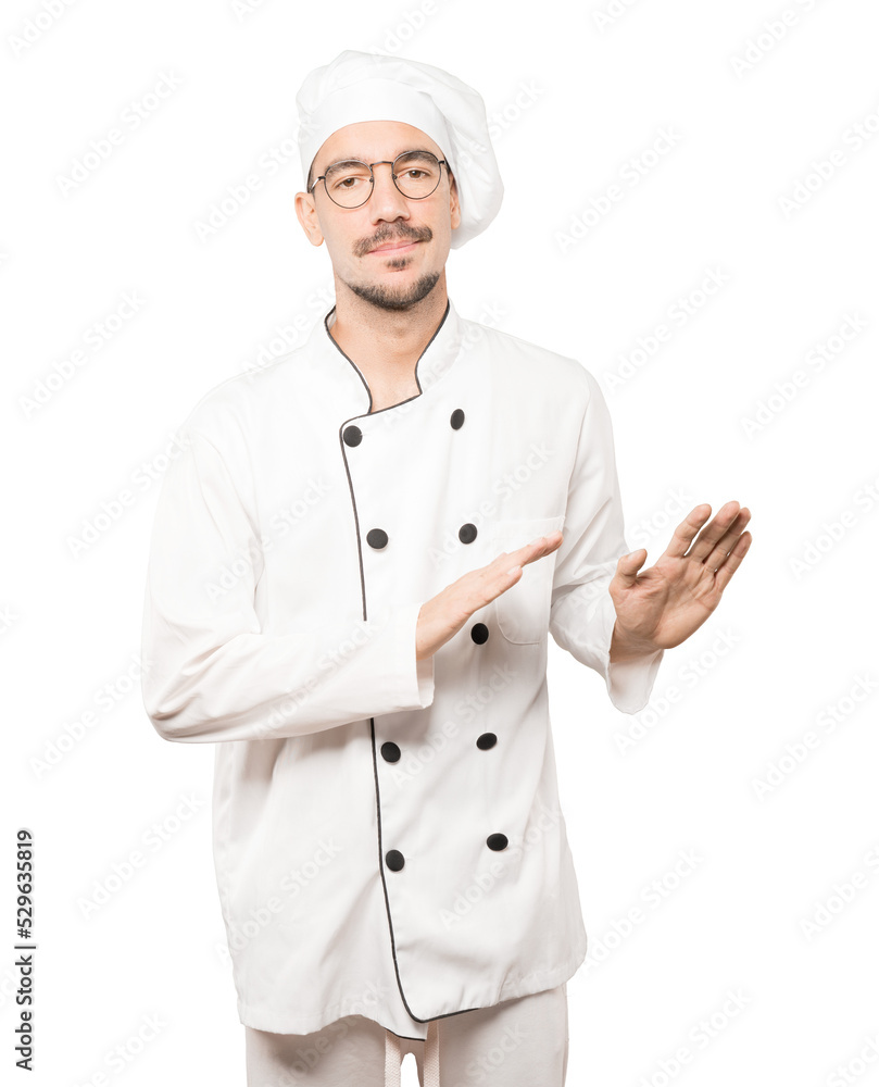 Doubtful young chef doing a gesture of keep calm Doubtful young chef doing a gesture of keep calm