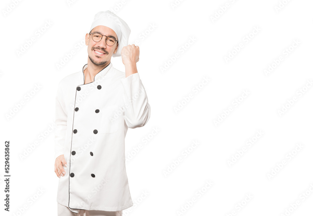 Happy young chef doing a competitive gesture Happy young chef doing a competitive gesture