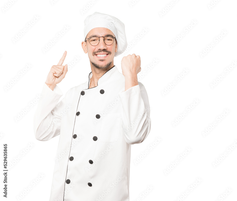 Happy young chef doing a competitive gesture Happy young chef doing a competitive gesture