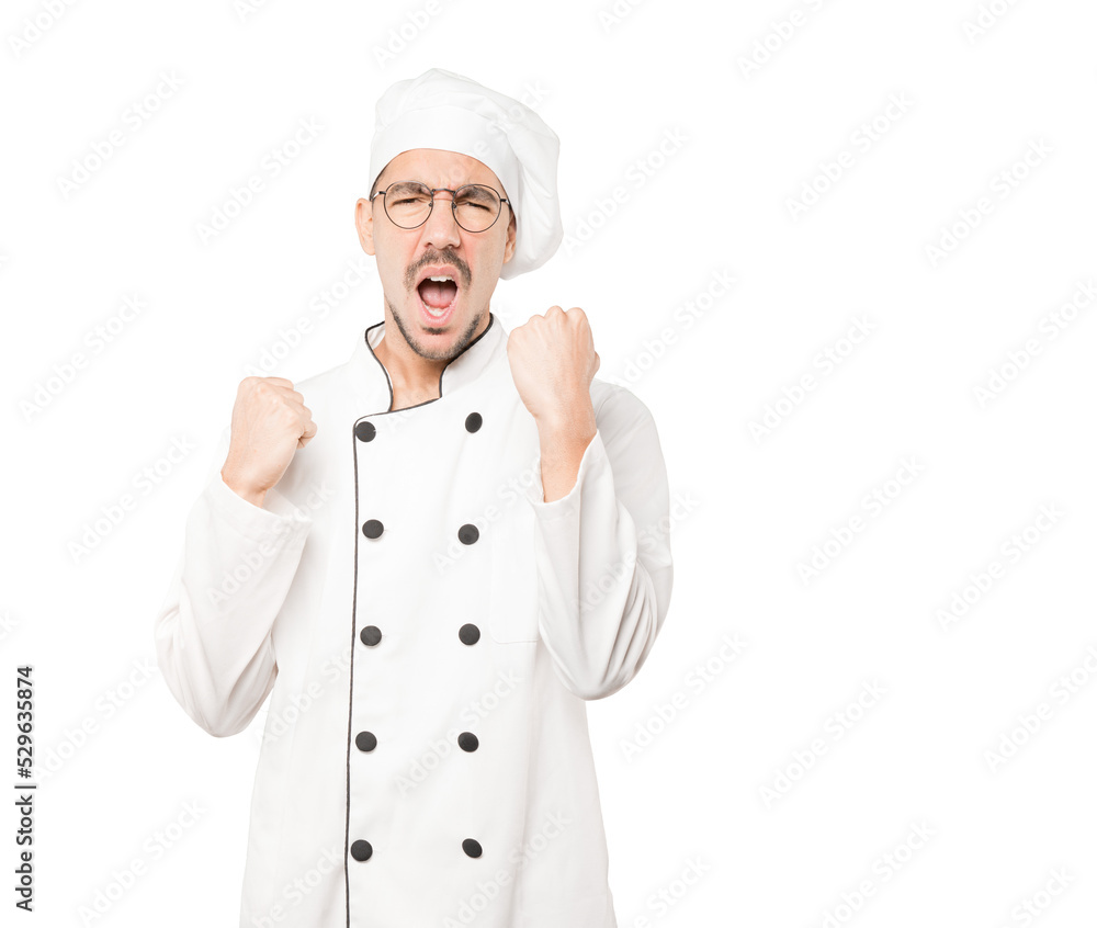 Upset young chef doing a competitive gesture Upset young chef doing a competitive gesture