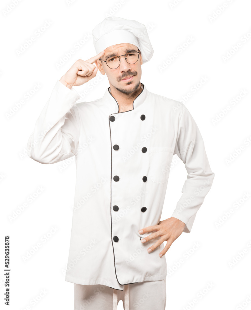 Serious young chef doing a gesture of concentration Serious young chef doing a gesture of concentration