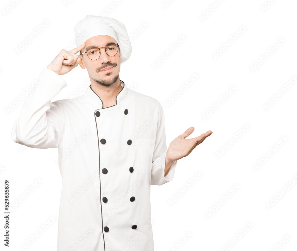 Serious young chef doing a gesture of concentration Serious young chef doing a gesture of concentration