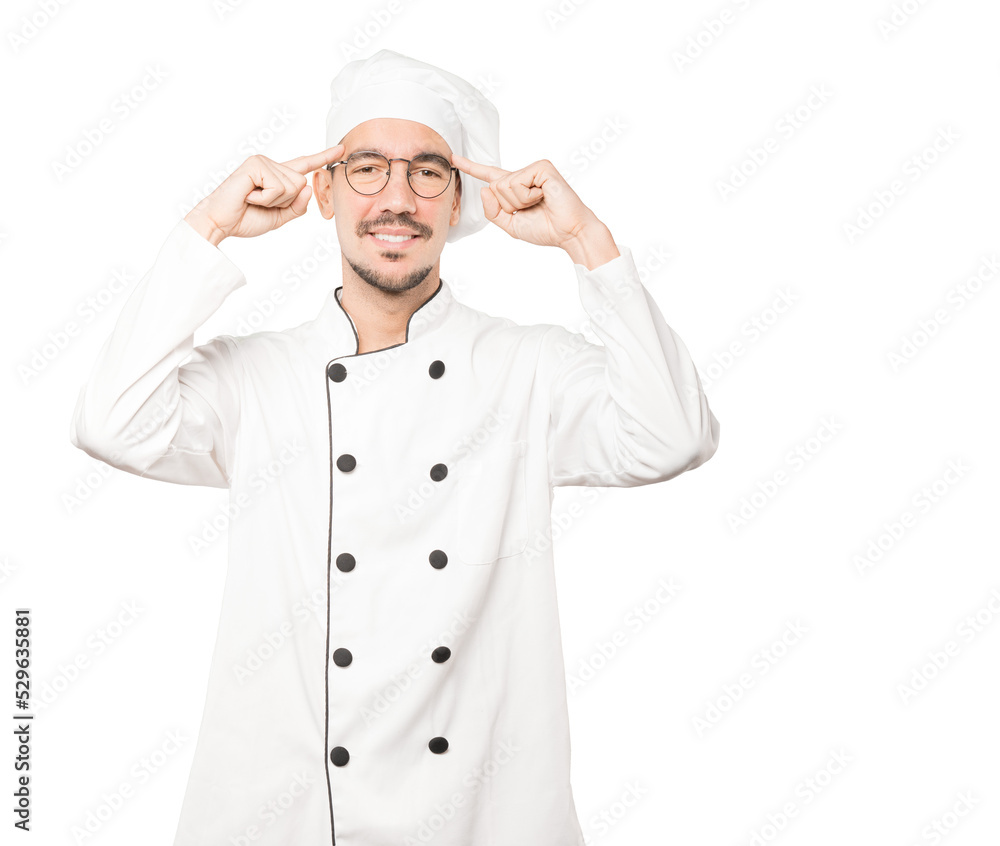 Happy young chef doing a gesture of concentration Happy young chef doing a gesture of concentration