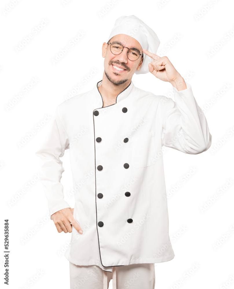 Happy young chef doing a gesture of concentration Happy young chef doing a gesture of concentration