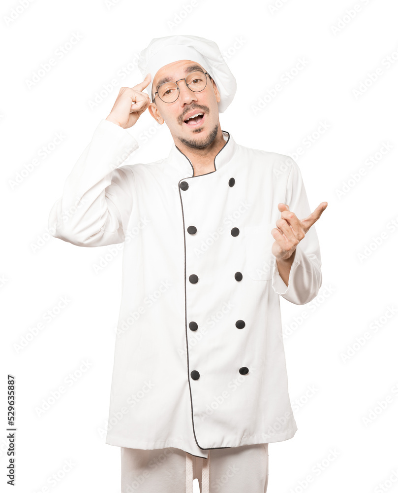 Surprised young chef doing a gesture of concentration Surprised young chef doing a gesture of concentration