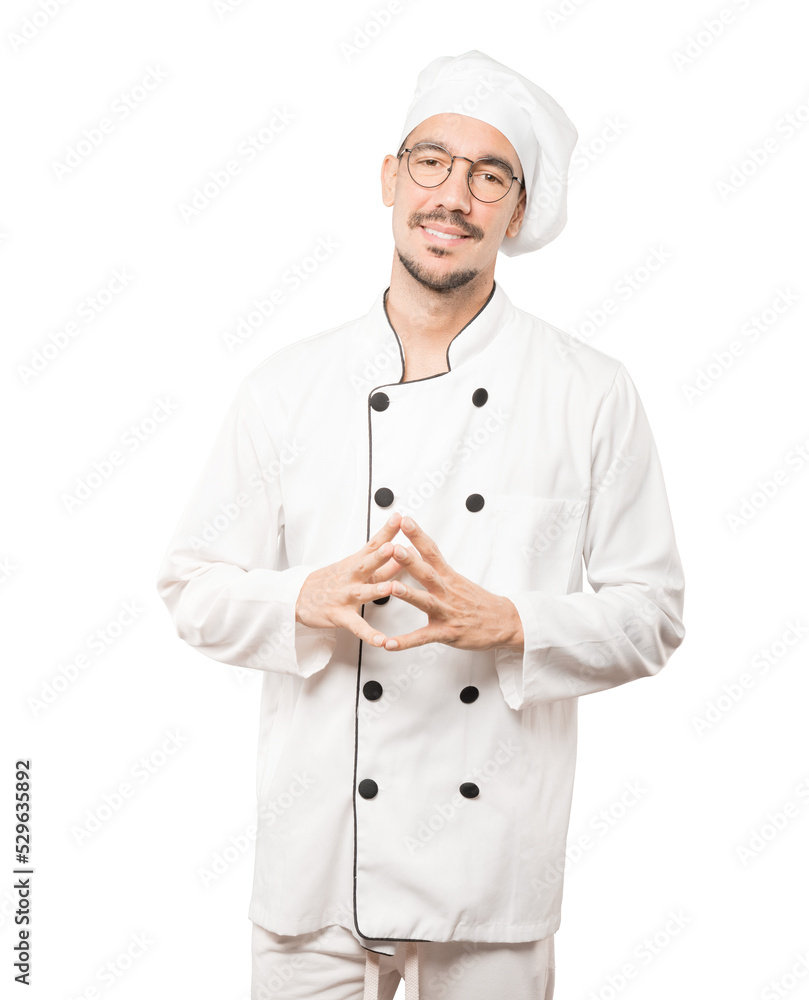 Friendly young chef doing a gesture of confidence Friendly young chef doing a gesture of confidence