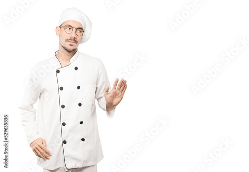 Doubtful young chef doing a gesture of keep calm