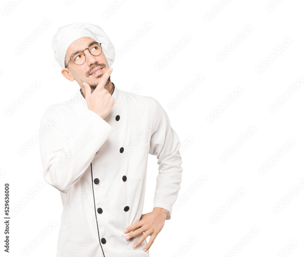 Happy young chef making a gesture of doubt Happy young chef making a gesture of doubt