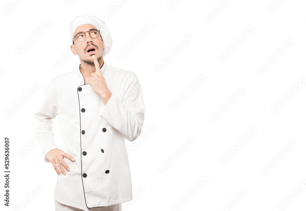 Surprised young chef making a gesture of doubt